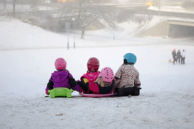 3 Kids sledding on a foggy winter day. 3 Kids sledding on a foggy winter day.